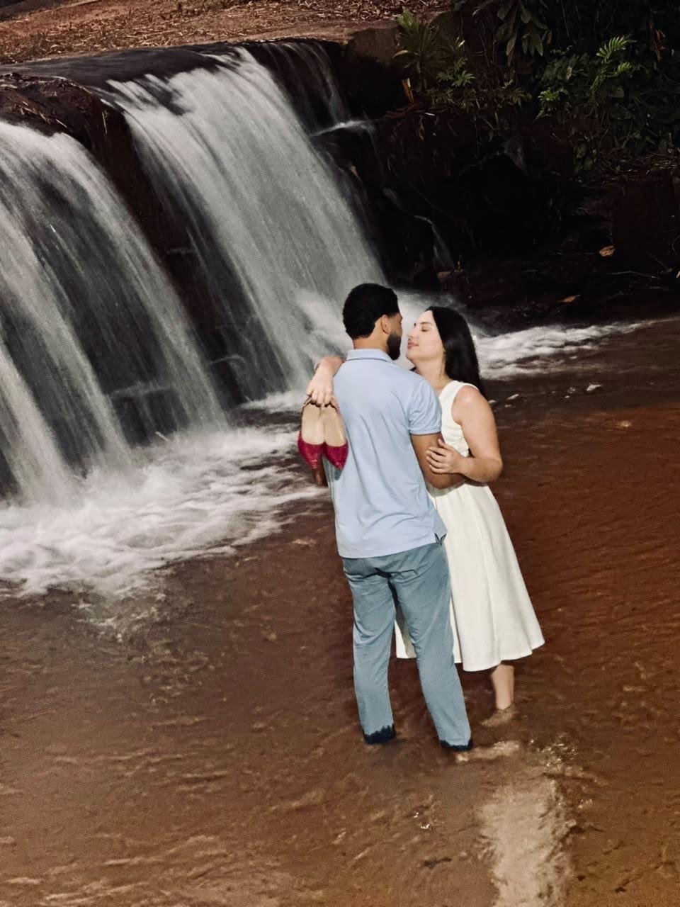 Daniele e Kauã abraçados diante de uma cachoeira